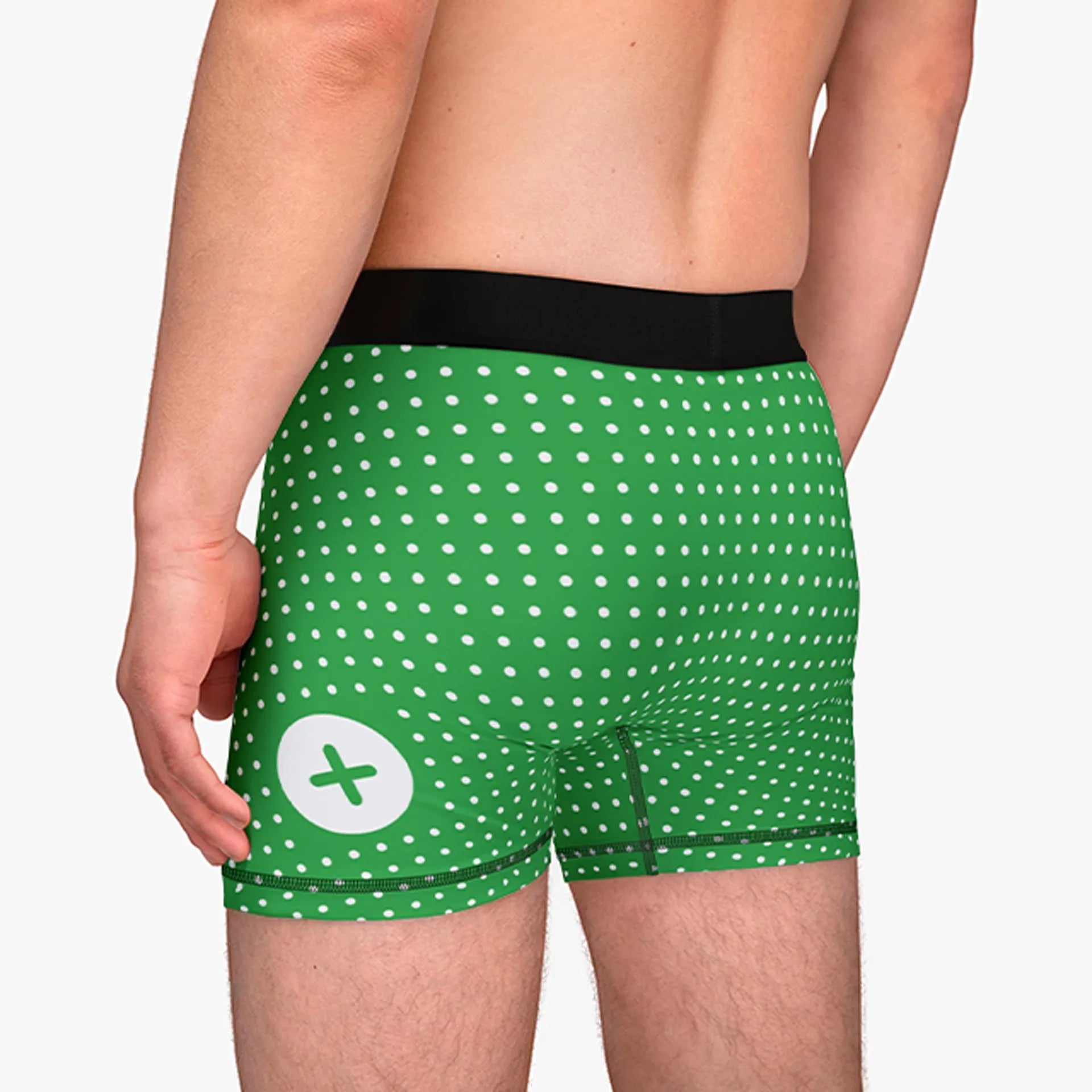 Man wearing green polka dot underwear with a white plus symbol on the side, showing a casual and fun style.